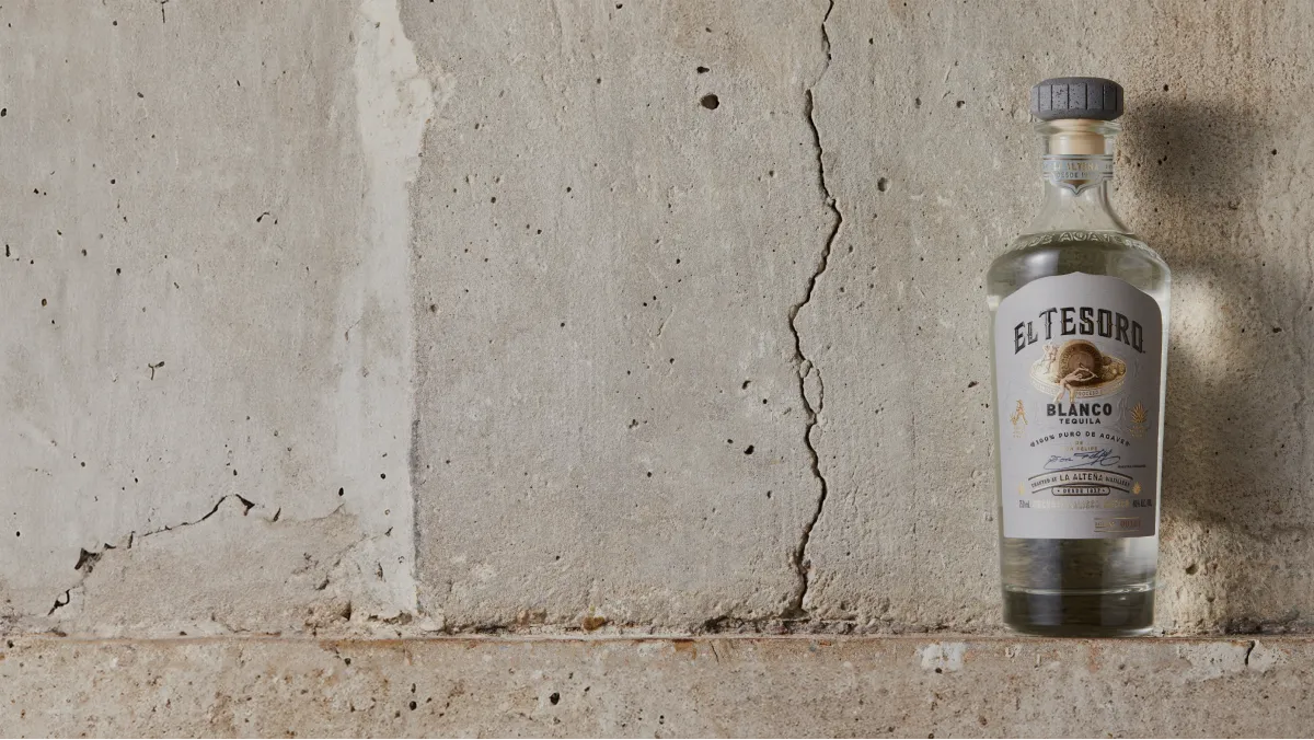 image of El Tesoro Tequila bottle placed beside a wall